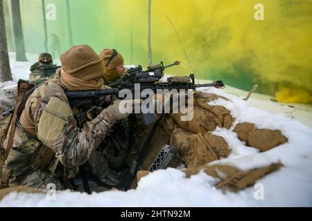 Personale Sgt. David Greenwood e i suoi compagni difensori assegnati allo Squadrone delle forze di sicurezza del 926th, con base alla base dell'aeronautica di Nellis, Nevada, si impegnano ad assalire i membri della forza opposta da una posizione scavata con M4 fuoco bianco durante un esercizio di difesa statica al Camp James A. Garfield Joint Military Training Center, Ohio, febbraio 15, 2022. L'esercizio faceva parte del corso sulla leadership della difesa integrata, un'intensa esperienza di apprendimento pratica di due settimane progettata per aiutare i difensori della riserva a raggiungere e mantenere la preparazione al combattimento. (STATI UNITI Air Force Photo/Eric M. White) Foto Stock