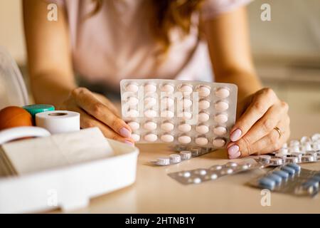 Le mani femminili blister pillole confezione primo kit aiutare l'organizzazione di conservazione. Vitamina, antidolorifico, cura di approvvigionamento Foto Stock