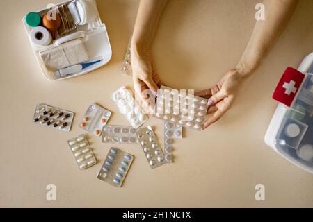 Le mani femminili blister pillole confezione primo kit aiutare l'organizzazione di conservazione. Vitamina, antidolorifico, cura di approvvigionamento Foto Stock