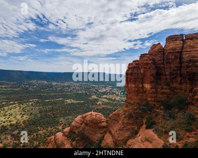 Vista panoramica di un'enorme formazione rocciosa con una valle e una città in lontananza. Foto Stock