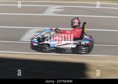 Vista laterale di un uomo in casco che guida go-kart sul circuito karting di  giorno Foto stock - Alamy