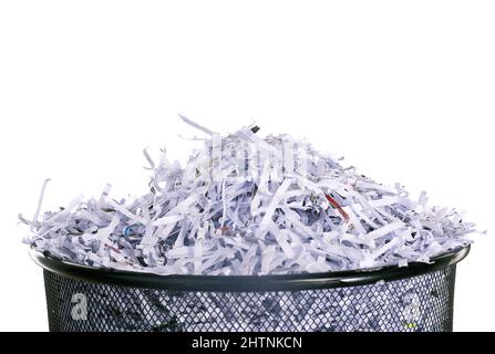 Non lasciamo alcuna traccia di prove. Foto studio di carta grattugiata in un cestino su sfondo bianco. Foto Stock