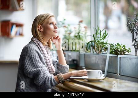 Abbiamo tutti bisogno di un posto per essere soli. Una giovane donna seduta in una caffetteria. Foto Stock