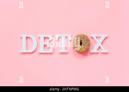 Testo Detox dalle lettere bianche del volume e dalla ciambella colorata su sfondo rosa. Concept Tea party, Donut Diet o IIFYM, problema di obesità e fast food, Foto Stock