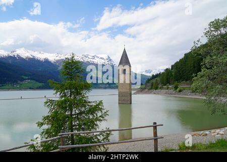 Una vista pittoresca sul lago di Resia e sul campanile affondato del Lago di Resia nella regione di Curon (Vinschgau, Alto Adige, Italia) Foto Stock