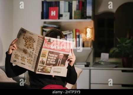 Parigi, Francia - 23 feb 2022: Donna che legge il giornale francese Aujord'hui con i titoli il presidente russo Vladimir Putin ottiene le sue mani su parte dell'Ucraina dopo aver firmato il riconoscimento delle regioni di Donbass Foto Stock