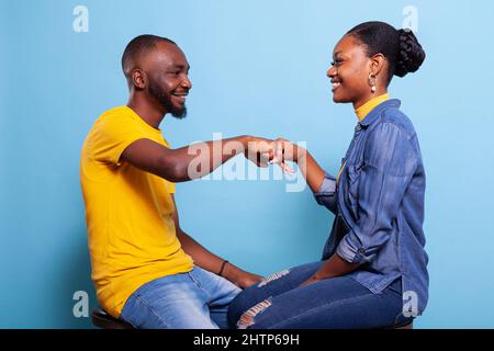 La gente felice che fa il segno di urto del pugno per celebrare il successo e il successo del lavoro di squadra. Uomo e donna che battono pugno d'accordo, partner sorridenti l'uno all'altro in studio. Simbolo trattativa. Foto Stock