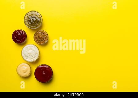 Diversi tipi di salse in ciotole su un pannello colorato . Vista dall'alto, vari salse copia spazio. Foto Stock