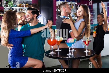 Coppia ballando tango al bar Foto Stock