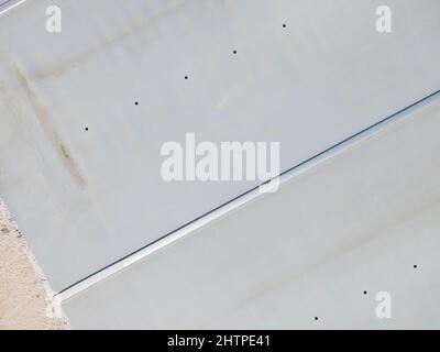 Drone volo su una piscina coperta con un tarp che è ancora in costruzione in un giardino Foto Stock