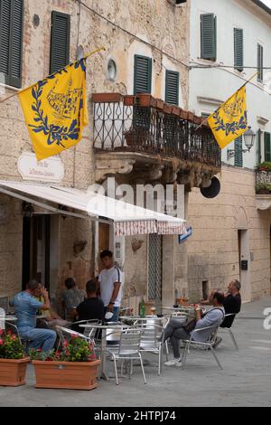 Vita quotidiana, caffetteria, villaggio di Asciano con bandiere dei distretti, Crete Senesi, provincia di Siena, Toscana, Europa Foto Stock