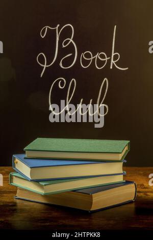 Libro Club, immagine tonata. Una pila di libri con la scritta del gesso su una lavagna Foto Stock