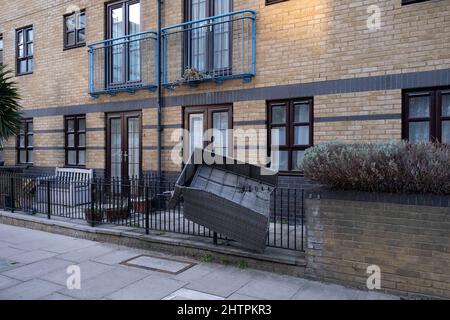 Damage vede un divano di mobili da giardino impalato su ringhiere a Wapping in seguito alla tempesta Eunice il 18th febbraio 2022 a Londra, Regno Unito. È stato messo in atto un avvertimento di tempo rosso per scoraggiare le persone a uscire in condizioni di pericolo. Foto Stock