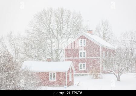 Nevicate di fronte alle case rosse Foto Stock