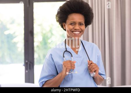 Ritratto di sorridente medico afroamericano di metà adulta con stetoscopio in ospedale Foto Stock