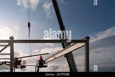 Moderno supermercato costruito dai lavoratori che erigano strutture in acciaio utilizzando grandi macchinari in un giorno di fine a Beverley, Regno Unito. Foto Stock