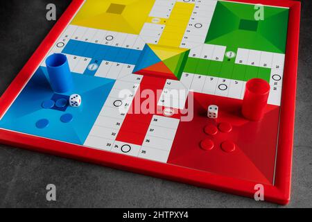 Tabellone classico Parcheesi con gettoni e dadi Foto Stock