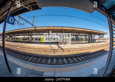 Fossano, Piemonte, Italia - 22 febbraio 2022: Stazione ferroviaria di Fossano con treni alla piattaforma, vista grandangolare, trasporto ferroviario regionale Foto Stock