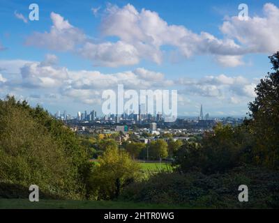 Londra da Parliament Hill Fields, alberi e cespugli davanti alla famosa vista dei grattacieli e degli edifici storici, sotto un luminoso cielo autunnale. Foto Stock