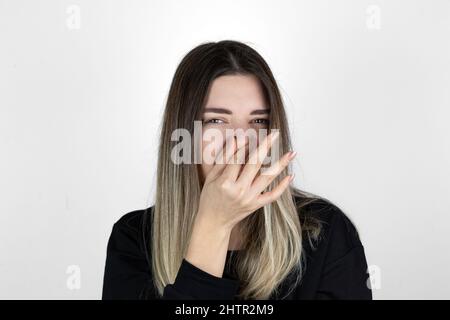 La donna dispiaciuta copre il naso con la mano, odora qualcosa di orribile, stringe il naso, frange in dispiacere, vede mucchio di spazzatura, vestito in abiti casual. Foto Stock