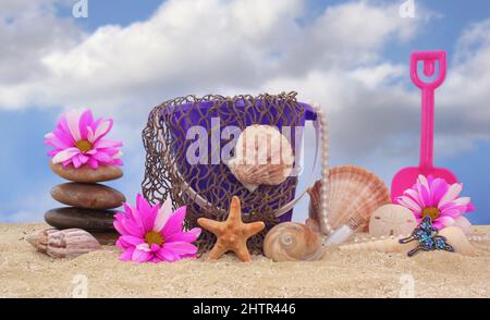 Secchio di sabbia con rete e conchiglie di mare su sabbia con cielo Foto Stock