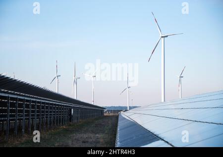 02 marzo 2022, Meclemburgo-Pomerania occidentale, Lübesse: Vista di un parco solare, turbine eoliche possono essere viste sullo sfondo. Foto: Daniel Bockwoldt/dpa-Zentralbild/dpa Foto Stock