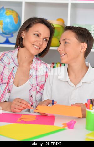 Porait di madre insegna al figlio di fare oggetti artigianali Foto Stock