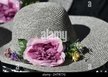 Cappello grigio sisal da donna con fiori artificiali su un negozio a Nafplio, Grecia. Foto Stock