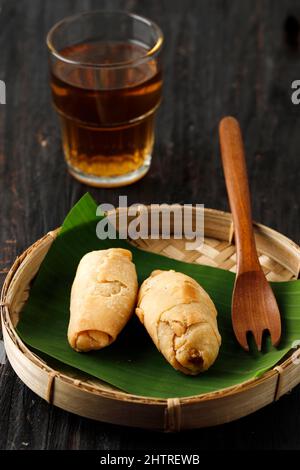 Pisang Molen Goreng, Deep Fried Banana con Sweet Batter Wrap, popolare Street Food indonesiano. Servito con tè Foto Stock