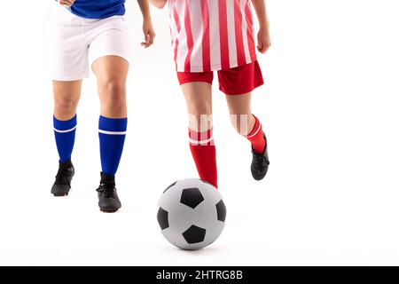 Sezione bassa di caucasici e biraciali giovani calciatori femminili che giocano a calcio Foto Stock
