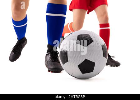 Sezione bassa di giovani donne caucasiche e biracali che giocano a calcio su sfondo bianco Foto Stock
