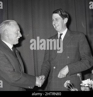 1960s, storico, il Duca di Atholl del 10th (Iain Murray) in una tuta di controllo con una giacca a doppio petto che agita la mano di un uomo in una presentazione, Scozia, Regno Unito. Un uomo alto, sei piedi, cinque pollici, conosciuto affettuosamente come 'Wee Iain', divenne il Duca del 10th nel 1957. Un titolo nella Peerage di Scozia e tenuto dal capo del Clan Murrary, risale al 1703 quando fu creato dalla regina Anna per John Murray, 2nd marchese di Atholl. La famiglia o casa ancestrale di Clan Murray è Blair Castle, vicino al villaggio di Blair Atholl, Perthshire. Foto Stock