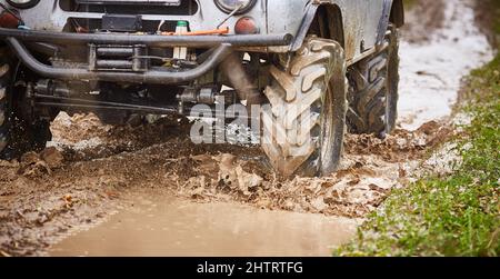 il carrello a trazione integrale sta guidando fuoristrada. Primo piano delle ruote. Guida fuoristrada Foto Stock