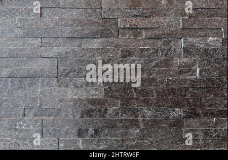 Strisce di pietra grigia. Moderno decorativo muro di pietra rivestimento texture sfondo. Foto Stock