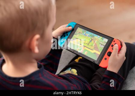 Wroclaw, Polonia - 27 GENNAIO 2022: Il ragazzo gioca a Nintendo Switch console. Nintendo Switch è una popolare console mobile. Foto Stock