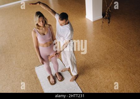 un uomo e una donna fanno yoga a tavola con le unghie in palestra. Foto Stock