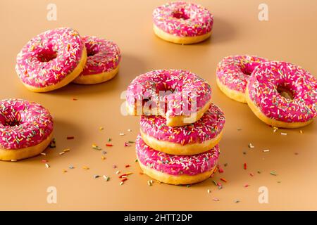Gruppo di ciambelle glassate rosa con spolverini colorati Foto Stock