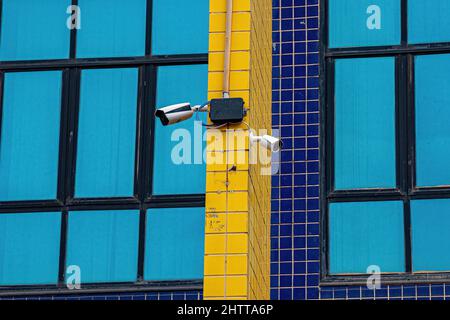 Due telecamere di sicurezza bianche su una parete esterna Foto Stock