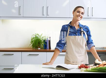 Un pasto casalingo è sempre il migliore. Una giovane donna pronta a cucinare. Foto Stock