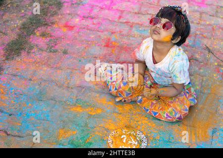 Tema Holi colorato - Ritratto di carino indiano vestendo tondi colori e dipinti in polvere di colore Holi chiamato Rang Gulal Foto Stock