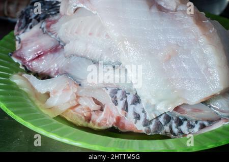 Filetto di pesce di tilapia crudo per cucinare in un piatto semplice di uso domestico e quotidiano. Foto Stock