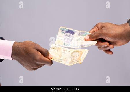 Primo piano di due persone che commerciano naira nigeriana e dollaro statunitense Foto Stock