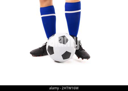 Sezione bassa di giovane donna biraciale in piedi da palla di calcio su sfondo bianco Foto Stock