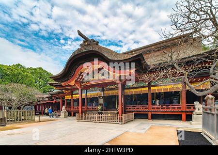 kyushu, fukuoka - dicembre 07 2019: I turisti che pregano nel santuario giapponese di Dazaifu dedicato a Sugawara no Michizane adorned con un roro di paglia ricurvo Foto Stock