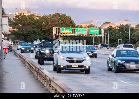 Washington, DC, Stati Uniti. Pendolari che si dedicano al jogging, alla bicicletta e alla guida a casa dopo il lavoro. Theodore Roosevelt Bridge, prima serata. U.S. Institute of Peace in backgr Foto Stock