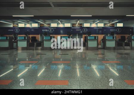 Una fila di cabine vuote per il check-in in un aeroporto internazionale con piccoli schermi LCD vuoti. Sportelli vuoti per il check-in dei passeggeri in un moderno aeroporto Foto Stock