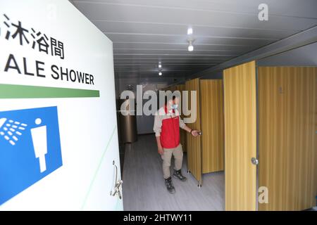 (220302) -- HONG KONG, 2 marzo 2022 (Xinhua) -- un membro del personale controlla le stanze delle docce presso l'impianto di isolamento comunitario (CIF) a Tsing Yi, Hong Kong della Cina meridionale, 2 marzo 2022. Un nuovo CIF ha iniziato ad ammettere il suo primo gruppo di pazienti COVID-19 a Hong Kong martedì sera. La struttura, situata a Tsing Yi, è aperta al servizio un giorno dopo che la sua costruzione è stata completata entro una sola settimana il lunedì con il supporto della terraferma. Il CIF, con la capacità di ospitare circa 3.900 pazienti, è una combinazione di cuccette modulari, con ogni stanza dotata di mobili di base Foto Stock