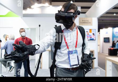 Barcellona, Spagna. 2nd Mar 2022. Un uomo prova i guanti e gli occhiali VR HaptX al Mobile World Congress (MWC) di Barcellona, Spagna, 2 marzo 2022. L'edizione 2022 del Mobile World Congress ha aperto le sue porte il 28 febbraio, per un evento di quattro giorni che dovrebbe ospitare tra 40.000 e 60.000 persone. Credit: Gustavo Valiente/Xinhua/Alamy Live News Foto Stock