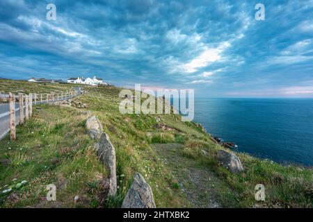 In estate al tramonto, nuvole soffici e campi rocciosi. Sentiero costiero per la scogliera, per i pedoni, che conduce a molti altri sentieri, passeggiate costiere, popu Foto Stock