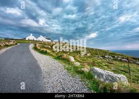 In estate al tramonto, nuvole soffici e campi rocciosi. Sentiero costiero per la scogliera, per i pedoni, che conduce a molti altri sentieri, passeggiate costiere, popu Foto Stock